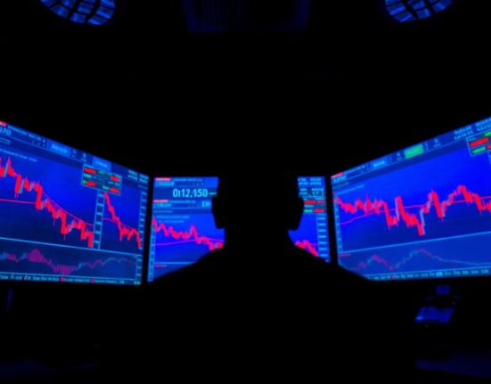 Trader monitoring cryptocurrency charts showing altcoin selling pressure and market decline