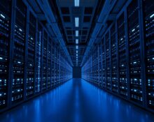 Interior view of a modern data center with rows of server racks and blue LED lighting