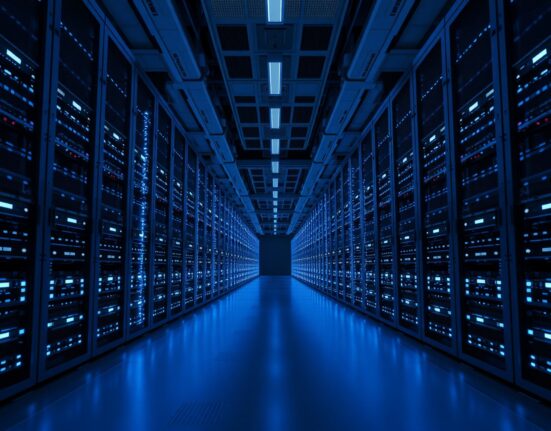 Interior view of a modern data center with rows of server racks and blue LED lighting