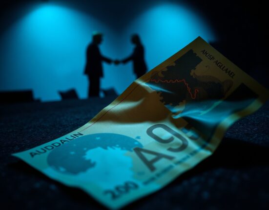 Australian dollar banknote with faint trade map overlay and distant silhouettes of Trump and Xi shaking hands.