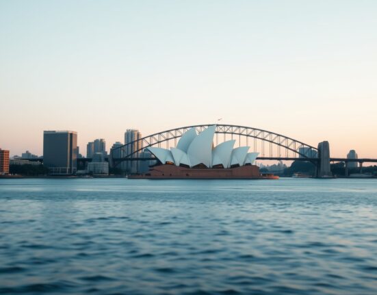 Sydney skyline at dawn with Opera House and Harbour Bridge in soft morning light
