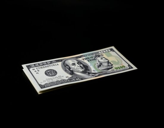 Australian and US dollar banknotes on a dark surface representing currency market analysis