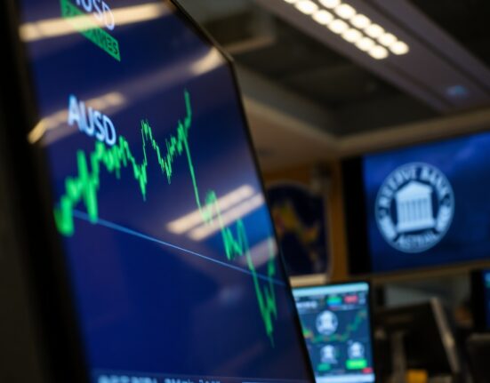 AUD/USD currency chart rising on a trading floor screen after RBA decision