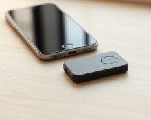 Autonomous Key NFC device next to a smartphone on a wooden desk