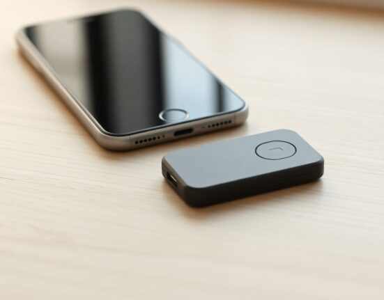 Autonomous Key NFC device next to a smartphone on a wooden desk