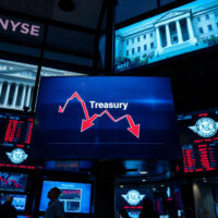 Stock market screens showing a downward trend after Treasury buyback announcement