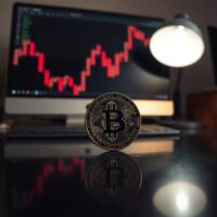 Bitcoin coin with a downward chart in the background, representing bearish market signals