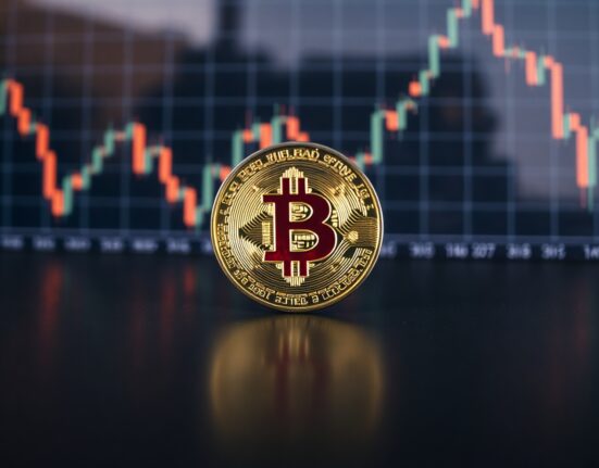 Bitcoin coin on reflective surface with financial chart in background