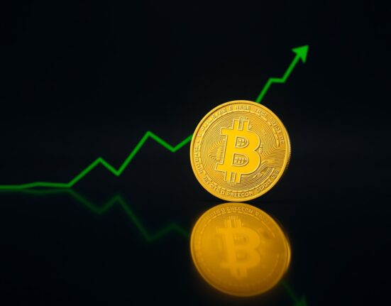 Bitcoin coin on reflective surface with upward-trending green graph line in background