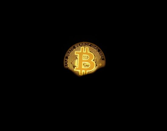 Bitcoin coin with shadow effect representing market decline