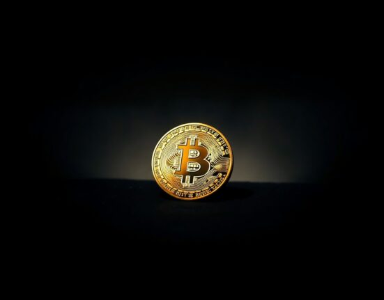 Bitcoin coin on dark surface with subtle digital background lines representing on-chain data analysis