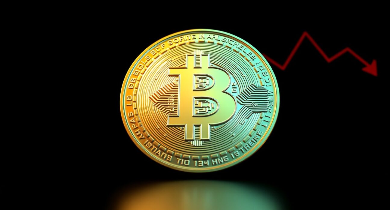 Bitcoin coin with downward trend indicators on dark background representing price drop below $77,000