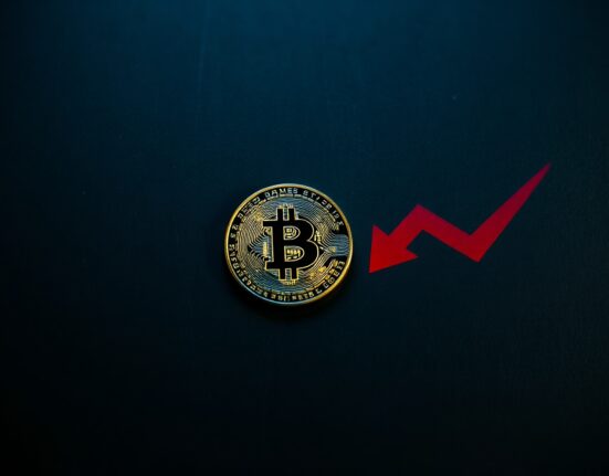 Bitcoin coin with a red downward shadow representing a bearish trend