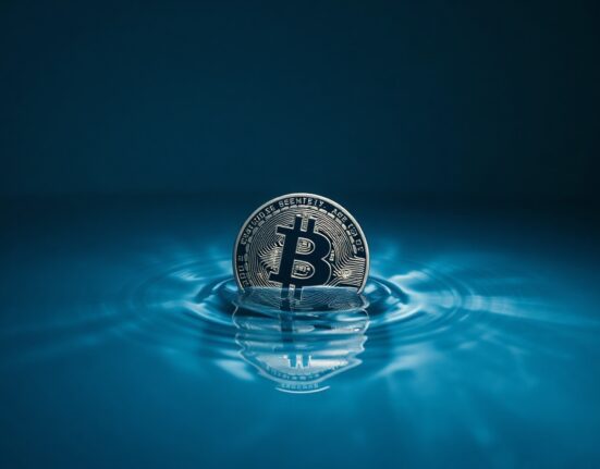 Bitcoin coin partially submerged in water representing liquidity pressure and market risk