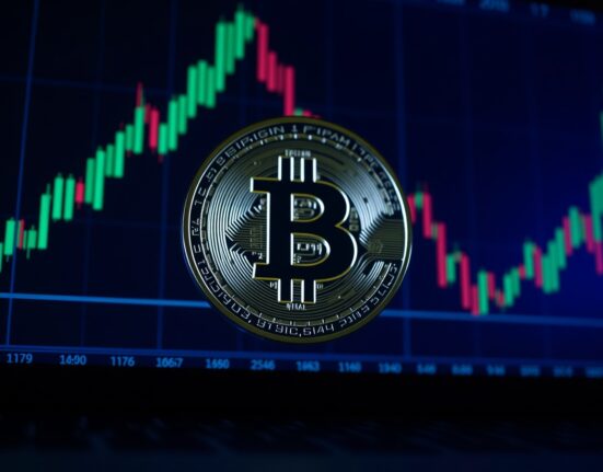 Bitcoin coin on dark trading screen with candlestick charts