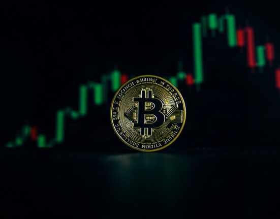 Bitcoin coin in foreground with a blurred chart of upward green candlesticks in the background