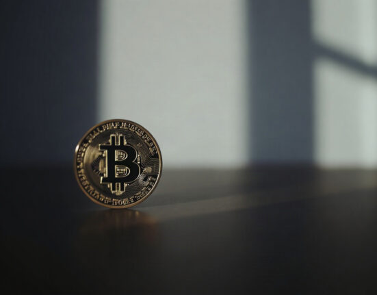 Bitcoin coin with a subtle upward price chart in the background, symbolizing improving market momentum.