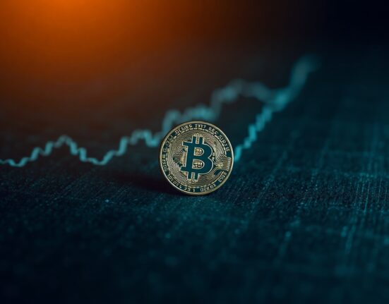 Bitcoin coin on a dark surface with a graph in the background, representing reduced selling pressure from long-term holders.