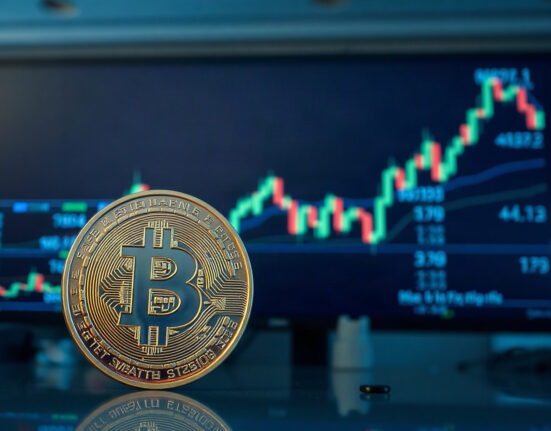 Bitcoin coin with declining volatility chart in background on trading floor
