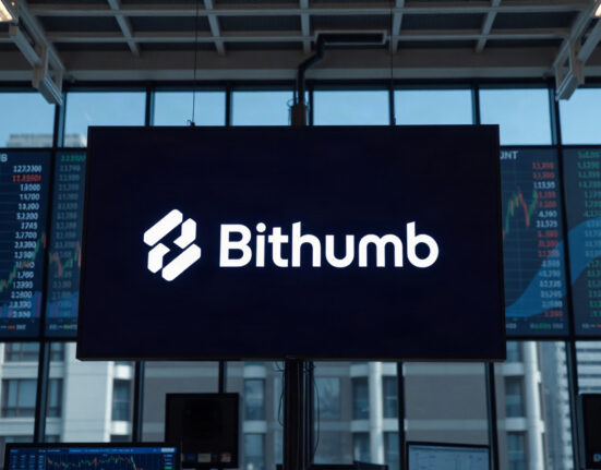 Bithumb exchange logo displayed on a screen in a modern trading environment
