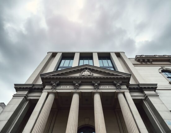 Bank of England building on a cloudy day, representing monetary policy decision.