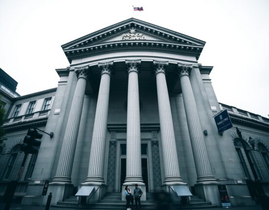 The Bank of England building in London on an overcast day, representing a monetary policy decision.