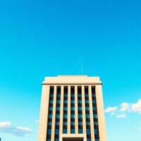 Bank of Japan building in Tokyo with subtle oil barrel icon overlay, representing BoJ June hike risk and oil shock analysis by TD Securities.