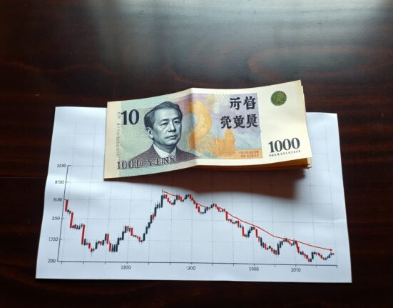 Japanese Yen banknote and financial chart illustrating BoJ policy impact