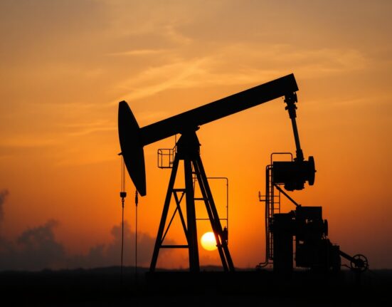 Oil pumpjack silhouette at sunset representing geopolitical supply risks for Brent crude