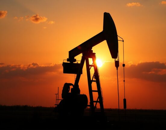 Oil pumpjack silhouette at sunset with a subtle map overlay, symbolizing geopolitical oil market risks.