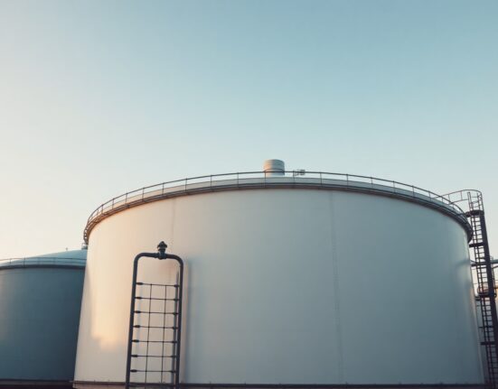 Brent crude oil storage tanks at an industrial facility during golden hour