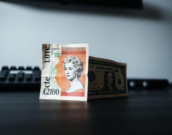 British Pound and US Dollar banknotes on a desk, representing forex market volatility.