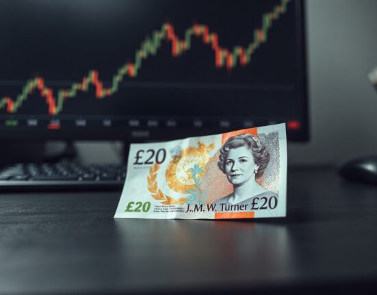British Pound banknote on desk with financial chart in background, symbolizing currency market resilience amid fiscal worries.