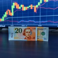 British pound and US dollar banknotes on a trading desk with a forex chart in the background