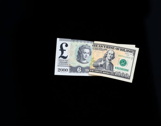 British Pound and US Dollar banknotes on a reflective surface, representing currency market analysis and GBP/USD exchange rate.