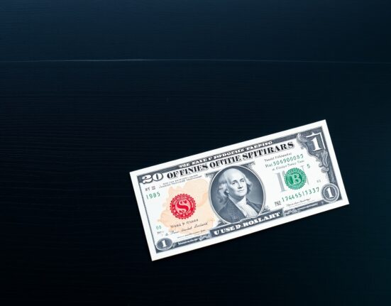 British Pound and US Dollar banknotes on desk, Pound angled down symbolizing decline