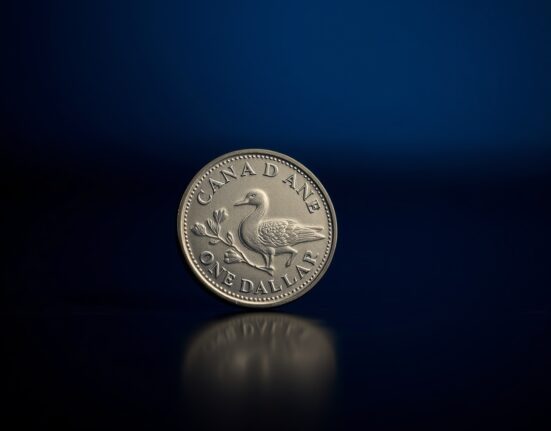 Close-up of a Canadian Loonie coin on a dark surface, representing currency weakness.