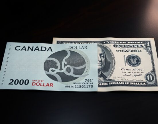 Canadian Dollar and US Dollar banknotes on a desk, representing forex market movement ahead of NFP data.