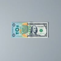 Canadian and US dollar banknotes on a surface with a blurred financial chart background