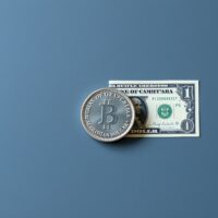 Canadian Dollar coin and US Dollar bill representing currency pair dynamics and safe-haven demand in forex markets.