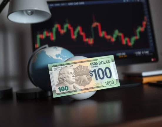 Canadian dollar banknote on desk with global map and financial chart in background