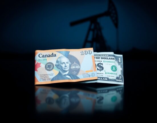 Canadian and US dollar banknotes on a reflective surface with an oil rig in the background, representing forex and oil market analysis.