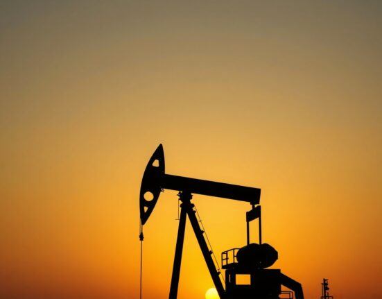 Oil pumpjack silhouette at sunset with geopolitical map overlay, representing easing oil risk from ceasefire talks.