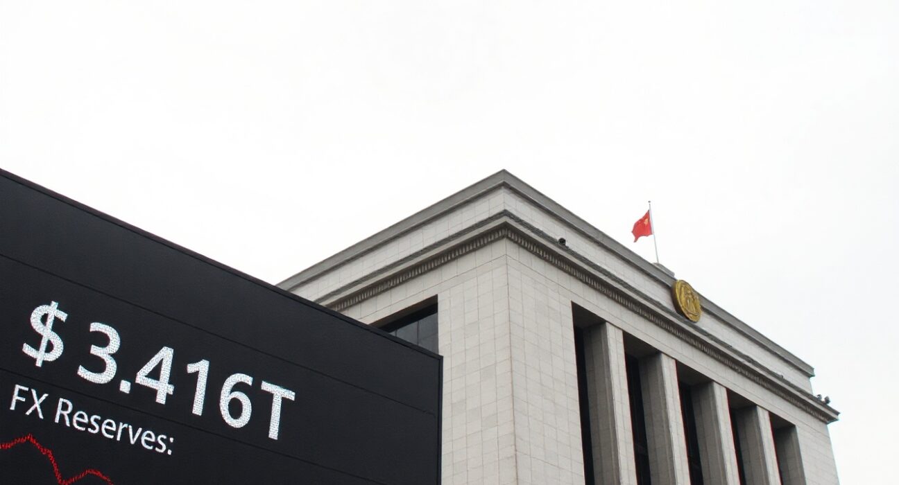 Exterior view of the People's Bank of China headquarters with an electronic display showing foreign exchange reserve data.