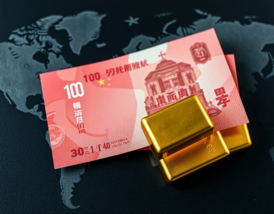 Chinese yuan banknotes and gold bars representing the currency's growing role as a global safe-haven asset.
