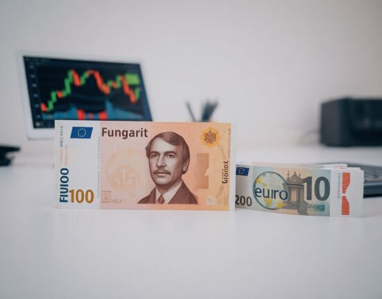 Hungarian forint banknotes with euro notes in background, symbolizing currency exchange and forex market analysis.