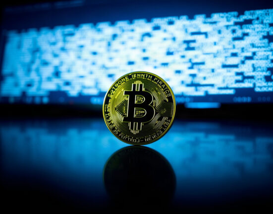 Bitcoin coin on a reflective surface with a blurred digital background, symbolizing cryptocurrency governance and protocol debates.