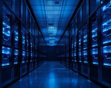 Interior of a modern data center with blue-lit server racks, representing data security infrastructure.