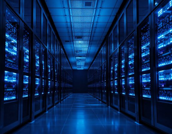Interior of a modern data center with blue-lit server racks, representing data security infrastructure.