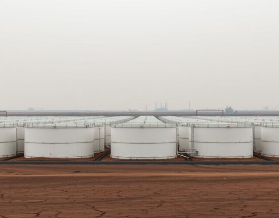 Empty oil storage tanks at an industrial terminal under overcast sky, representing bearish oil market outlook.